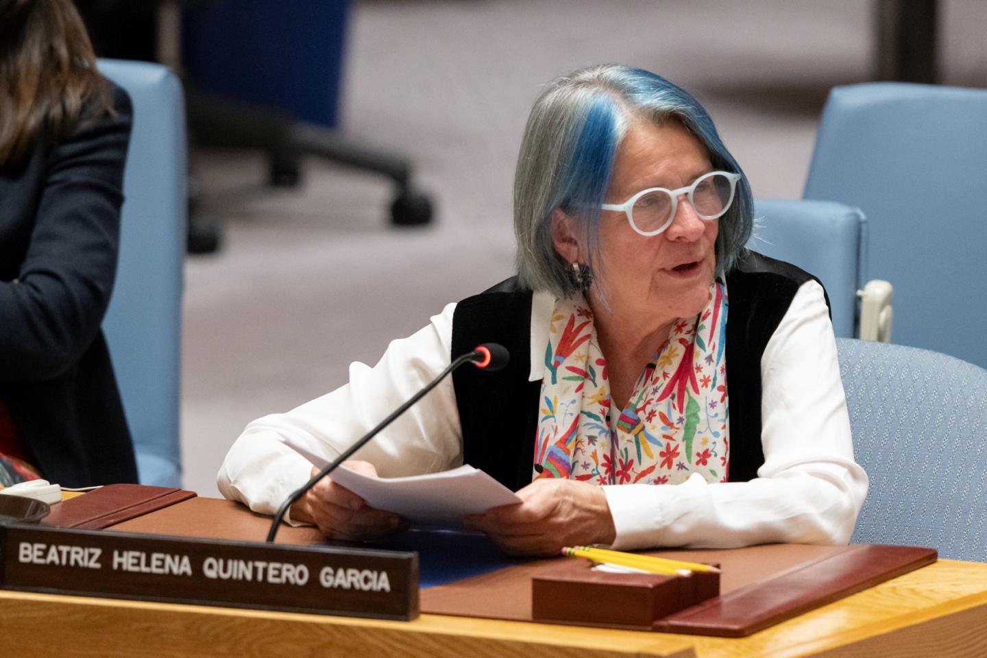 Woman seated behind table during meeting.