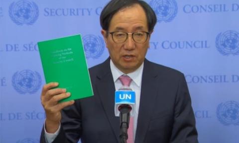 A man stands at a podium and briefs journalists on the working methods of the Security Council